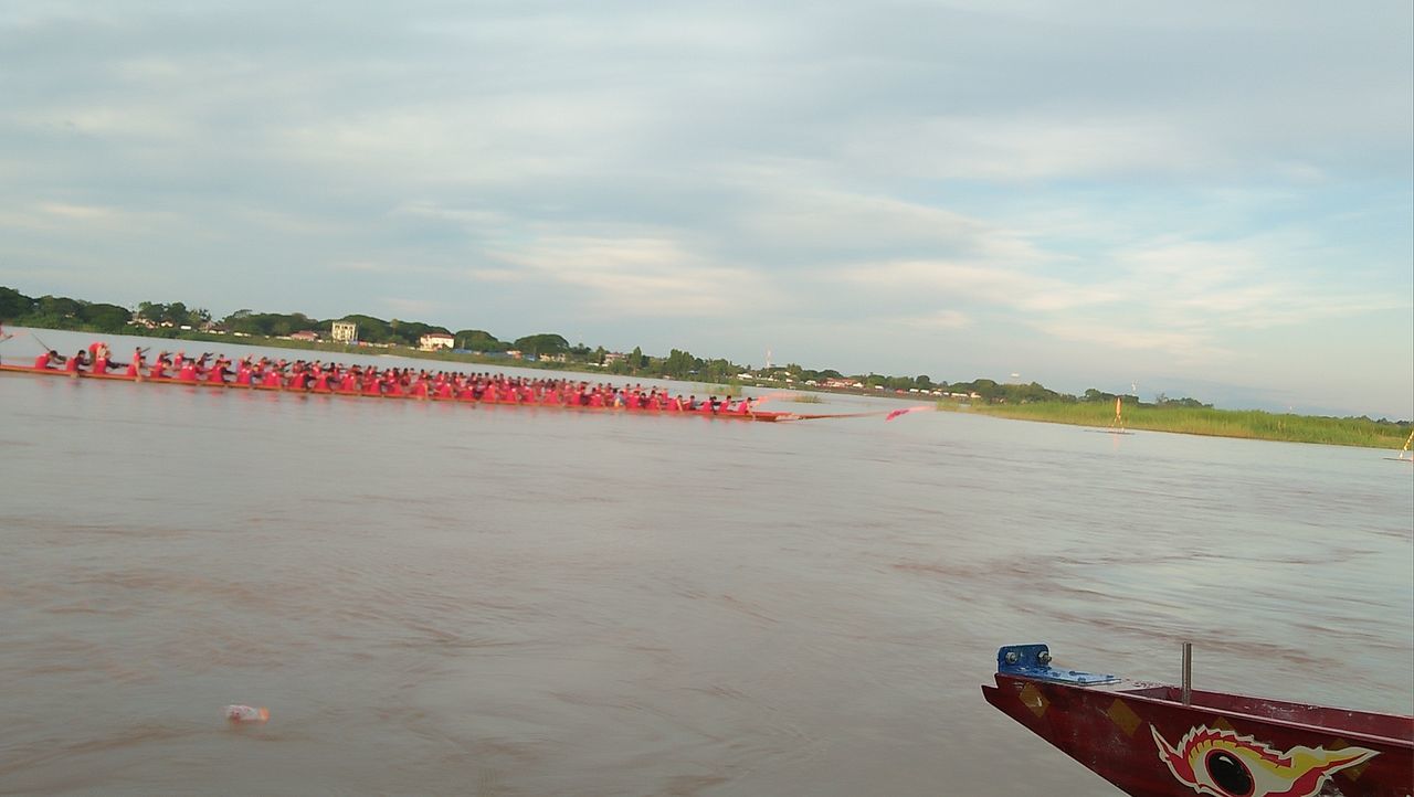 BOAT MOORED ON SHORE AGAINST SKY