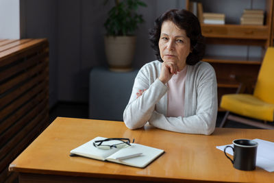 Young woman using mobile phone while sitting at home