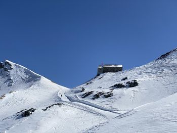 Snow covered mountain against clear blue sky