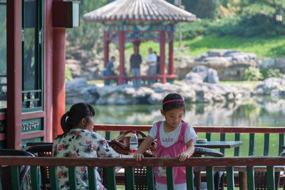 Portrait of girl sitting on railing