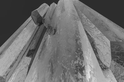 Low angle view of icicles on roof against sky