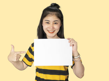Portrait of a smiling young woman against gray background