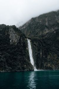 Scenic view of waterfall against sky