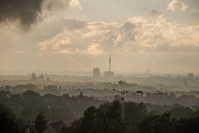 View of cityscape against cloudy sky