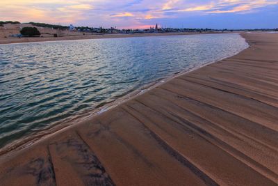 Scenic view of beach against sky during sunset