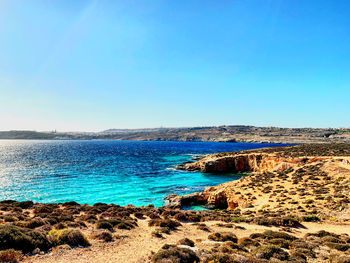 Scenic view of sea against clear blue sky