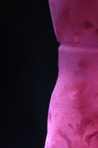 Close-up of purple statue against black background