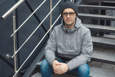 Portrait of man sitting on steps outdoors