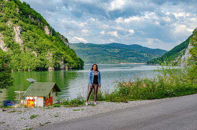 Rear view of woman walking on road against mountain