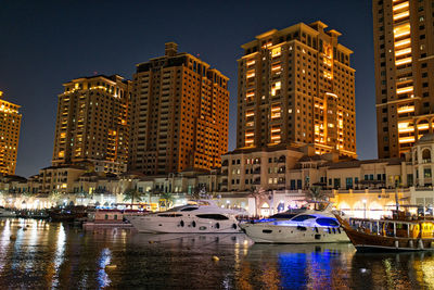 Boats in river with buildings in background