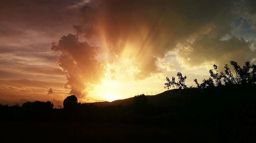 Silhouette of landscape against cloudy sky