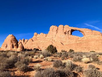 Rock formations on landscape against blue sky