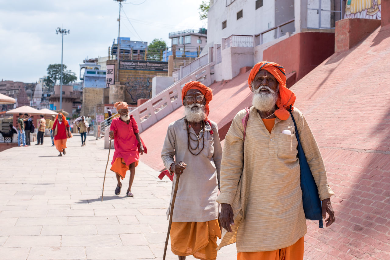 architecture, building exterior, city, built structure, group of people, day, real people, walking, street, clothing, sunlight, adult, men, women, people, nature, three quarter length, outdoors, protection, incidental people, uniform, warm clothing