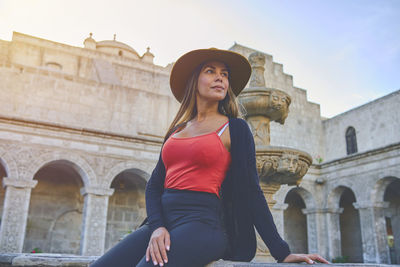 Young woman standing against historic building