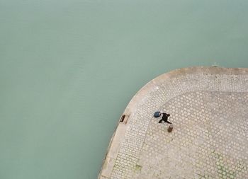 High angle view of man walking on pier by sea