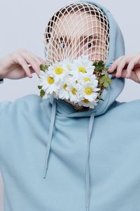 Young man covering face with flowers