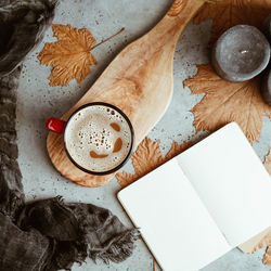 High angle view of coffee cup by book on table