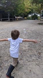 Rear view of boy with arms raised