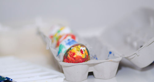 Close-up of painted eggs in carton on table