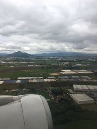 Aerial view of town against cloudy sky