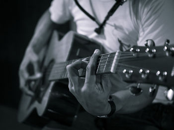 Close-up of man playing guitar at night