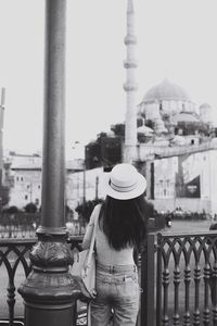 Rear view of woman standing by railing