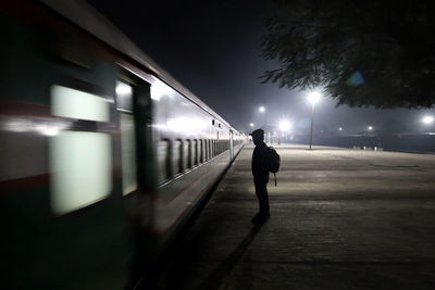 Rear view of man walking on railroad station