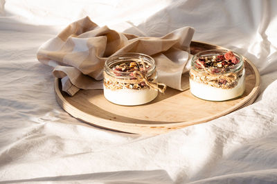 Quick healthy breakfast greek yogurt, granola with dried berries and nuts in glass jar.