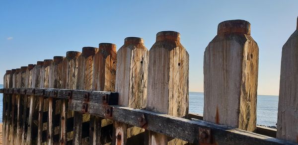 Panoramic view of wooden posts against clear sky