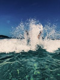 Man splashing water in sea against sky