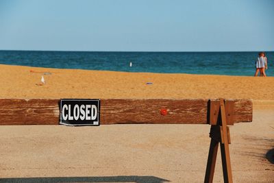 Closed text on wooden barricade at beach