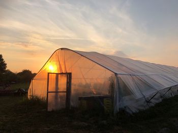 Tent on field against sky during sunset