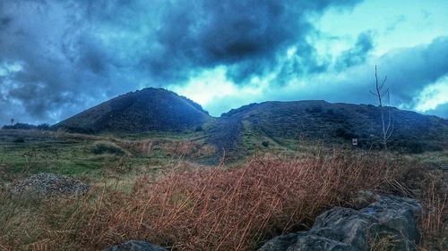 Scenic view of mountains against cloudy sky