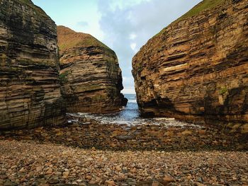 View of rocks on shore against sky