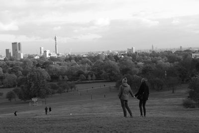 Rear view of people walking on landscape