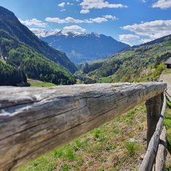 Wooden fence on landscape against sky