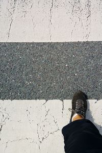 Low section of man standing on road