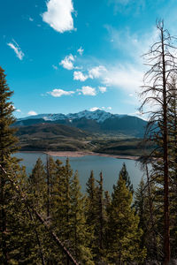 Scenic view of lake by mountains against sky