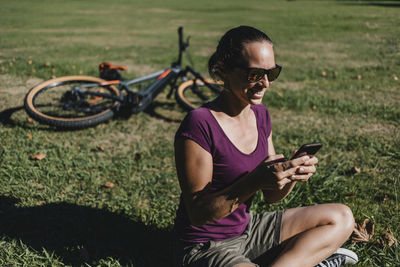 Midsection of man using mobile phone in field