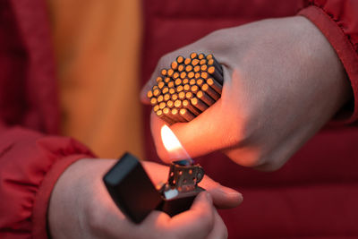 Close-up of hand holding lit candle