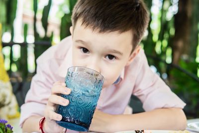 Portrait of boy drinking water outdoors