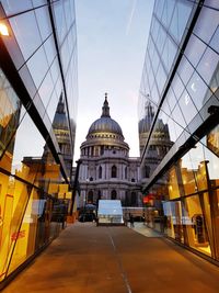 Road amidst glass buildings leading towards st paul cathedral at dusk