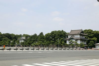 Trees by built structure against sky