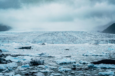 Majestic glacier against cloudy sky