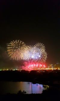 Firework display over river at night