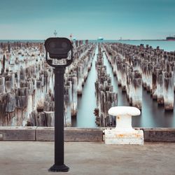 Panoramic view of wooden posts in sea against clear sky