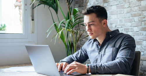 Young man using laptop at home