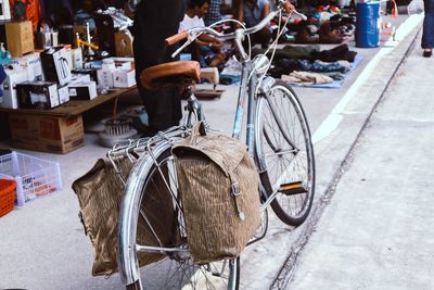 Low section of people with bicycle on road in city