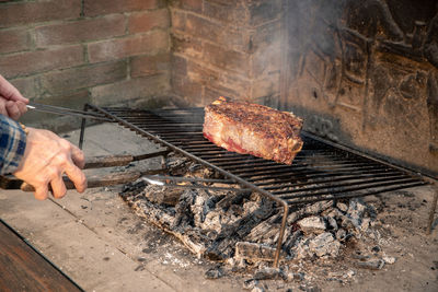 Italian roasted steak on a barbeque grill appetizing meat cooking on fire and embers in the backyard