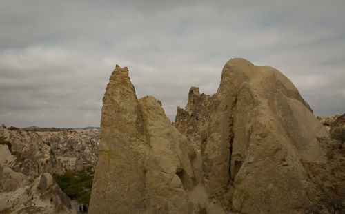 Low angle view of rock formations against cloudy sky